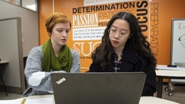 a person sitting at a table in front of a laptop a person sitting at a table in front of a laptop