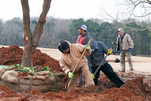 a group of people walking down a dirt road