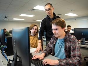 a group of people looking at a laptop