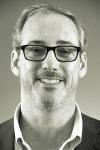 a man wearing glasses and smiling at the camera a man wearing glasses and smiling at the camera