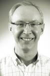 a man wearing glasses and smiling at the camera a man wearing glasses and smiling at the camera