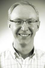 a man wearing glasses and smiling at the camera a man wearing glasses and smiling at the camera