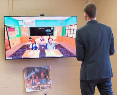 a man standing in front of a screen a man standing in front of a screen