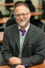 Paul Hard in a suit sitting at a table