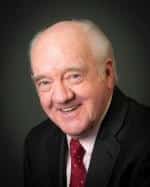 Richard Herd wearing a suit and tie