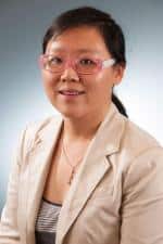 a woman wearing glasses and smiling at the camera a woman wearing glasses and smiling at the camera