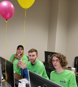 a group of people sitting at a table with a laptop a group of people sitting at a table with a laptop