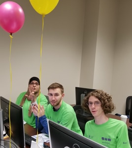 a group of people sitting at a table with a laptop