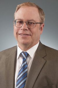 a man wearing glasses and a suit and tie