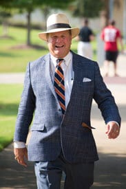 a man wearing a suit and tie walking down the street