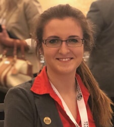 a woman wearing glasses and smiling at the camera