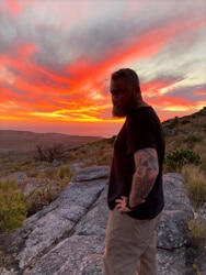 a man standing in front of a sunset