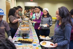 a group of people sitting at a table with a cake