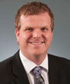 a man wearing a suit and tie smiling at the camera a man wearing a suit and tie smiling at the camera