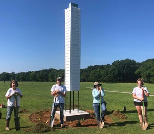 a group of people standing on top of a grass covered field a group of people standing on top of a grass covered field