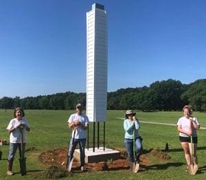 a group of people standing on top of a grass covered field