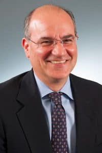 a man wearing a suit and tie smiling at the camera a man wearing a suit and tie smiling at the camera
