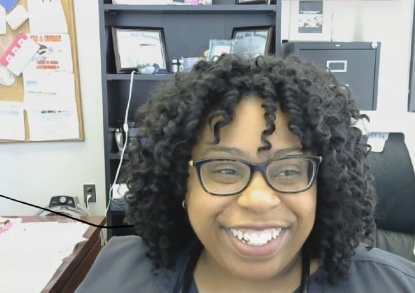 a person wearing glasses and smiling at the camera