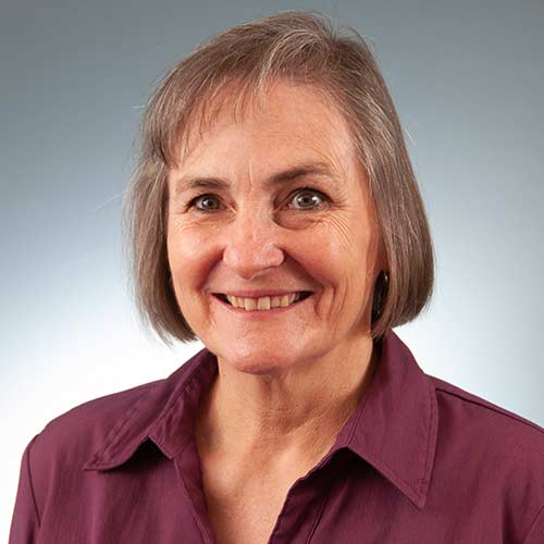 a person wearing a purple shirt and smiling at the camera