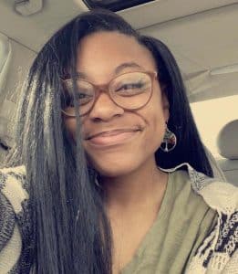 a woman wearing glasses and smiling at the camera a woman wearing glasses and smiling at the camera