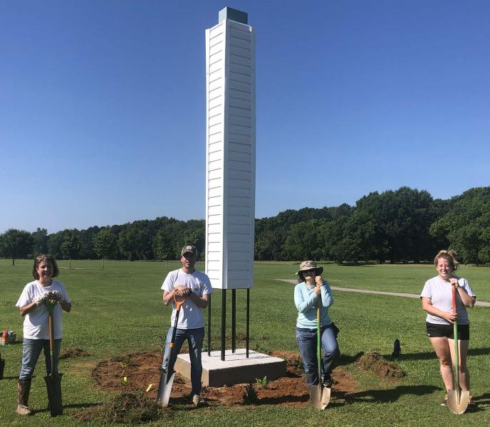 a group of people standing on top of a grass covered field