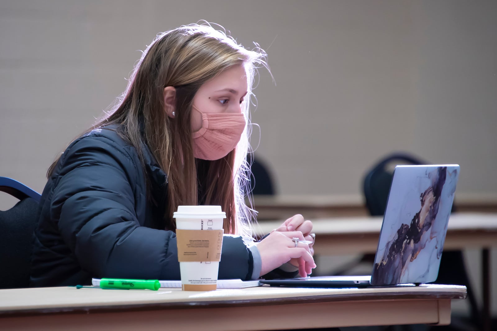 a woman sitting at a table using a laptop computer