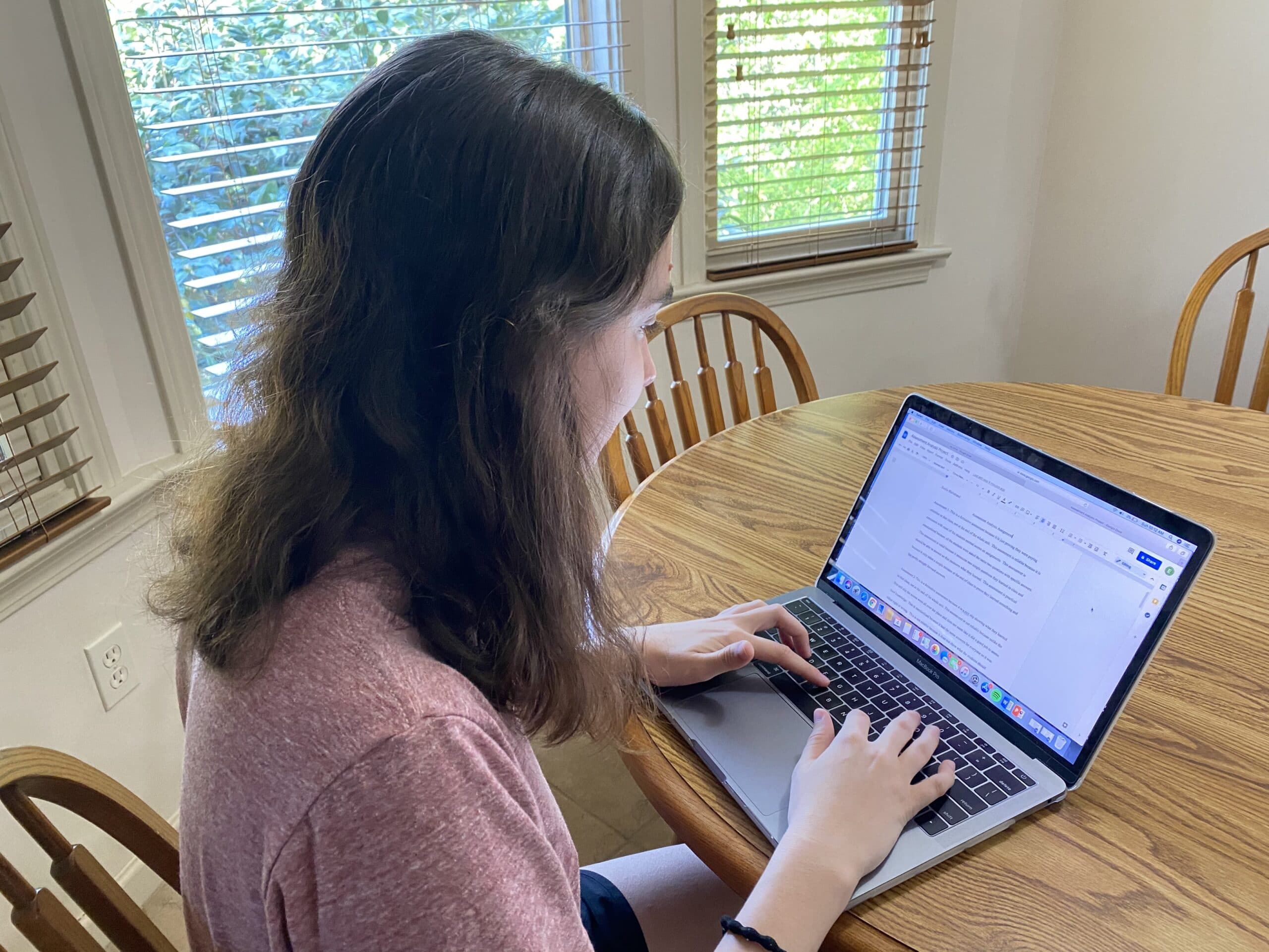 a woman sitting at a table using a laptop