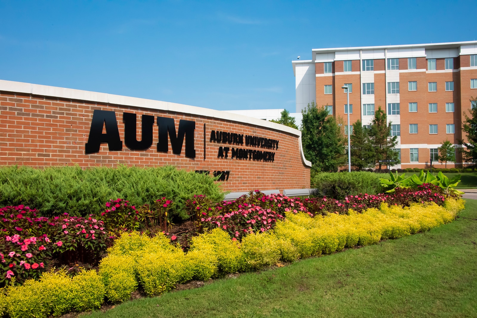 a large brick building with green grass