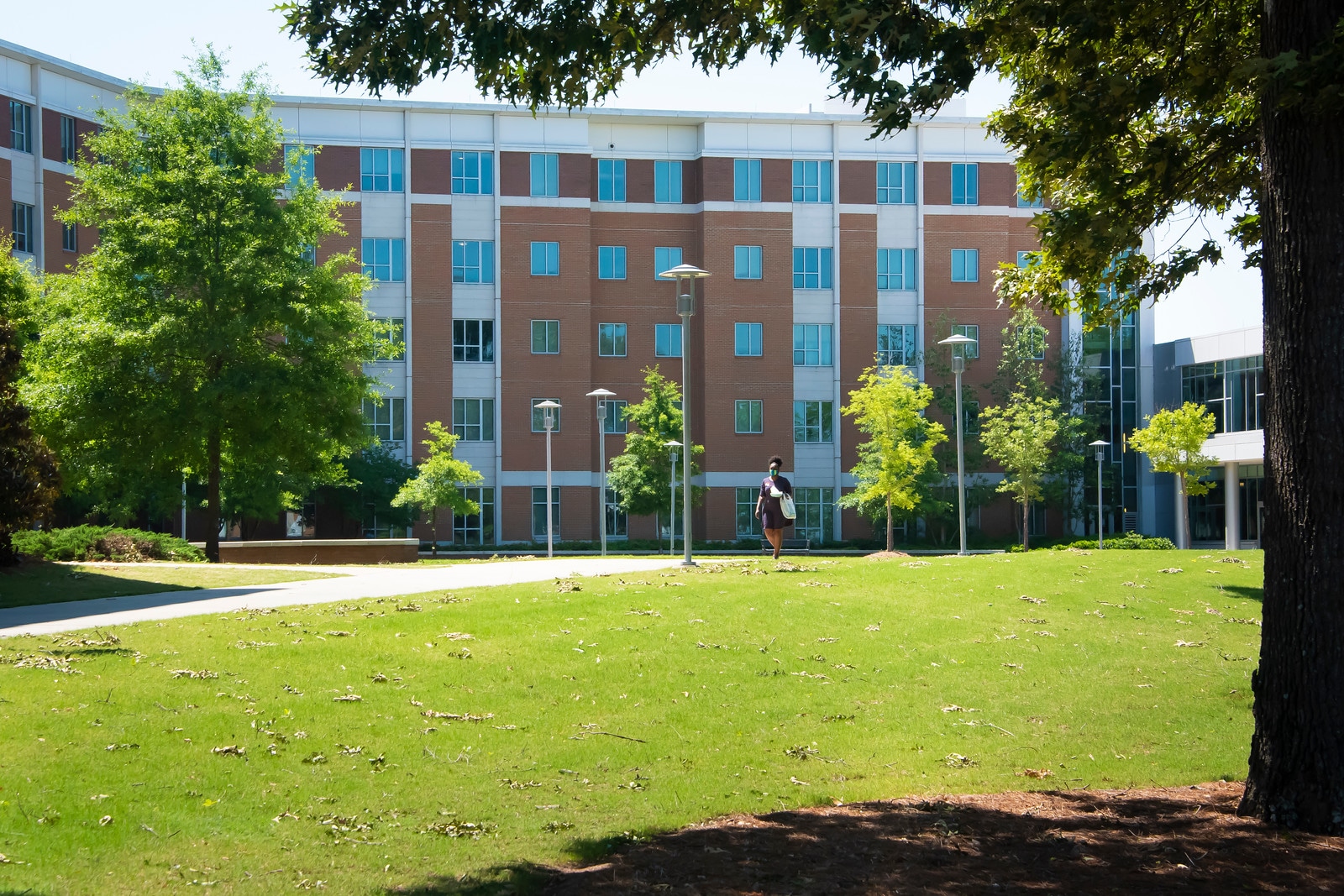 a large brick building with green grass and trees