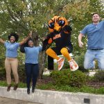 Jumping AUM students with warhawk mascot