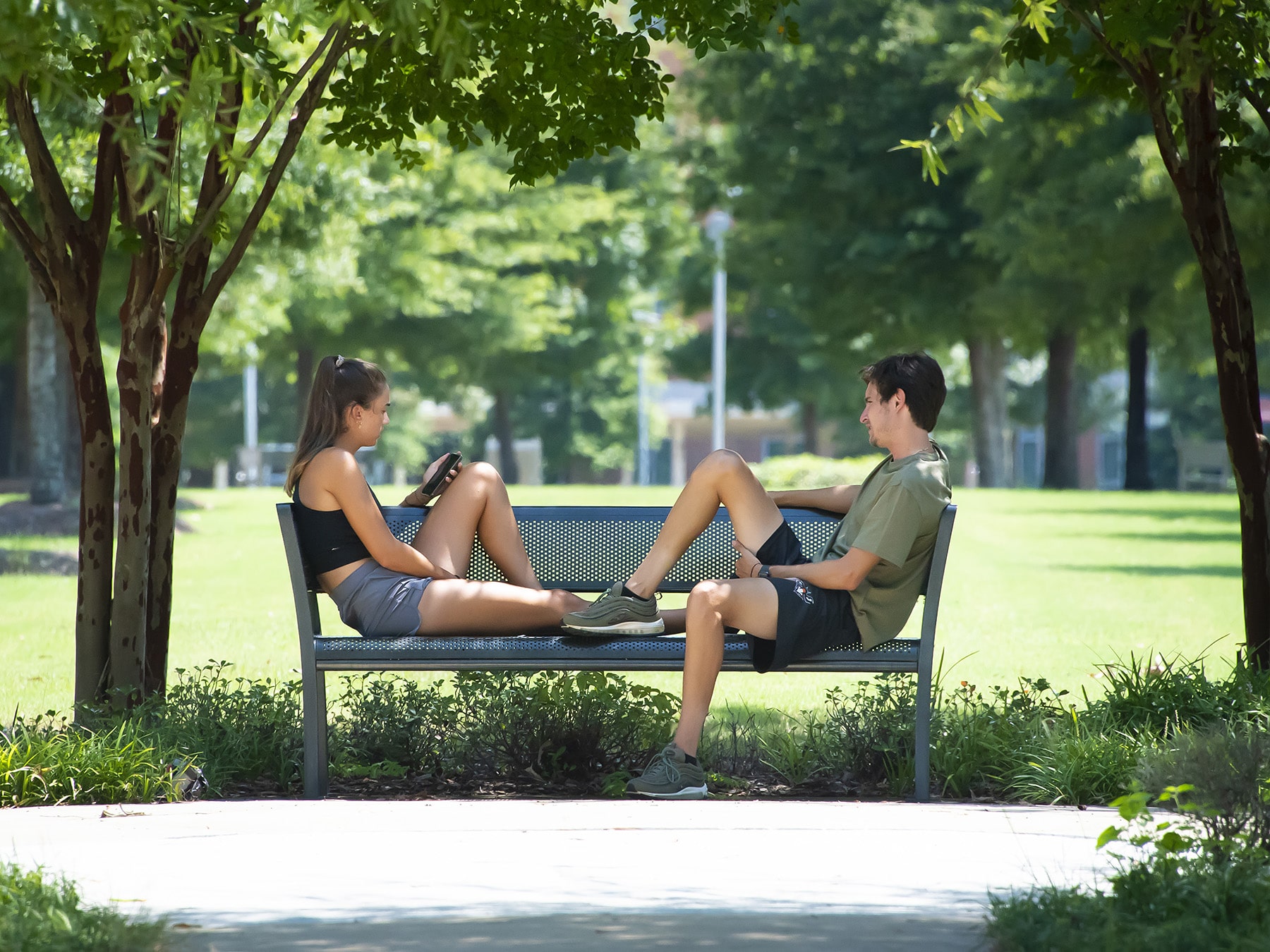 a person sitting on a bench in a park