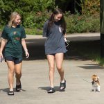 Riley Copeland and Kyndall Foley walk a small dog on campus named Alfredo