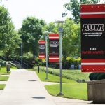 flag posts with "Go Warhawks" banners along walk way on AUM's campus