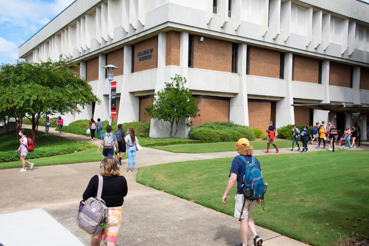 Students walk around campus in front of Goodwyn Hall.