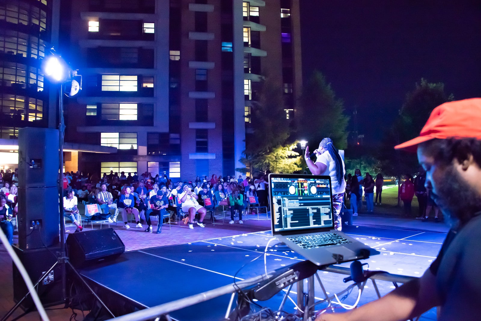 a group of people performing on stage in front of a building