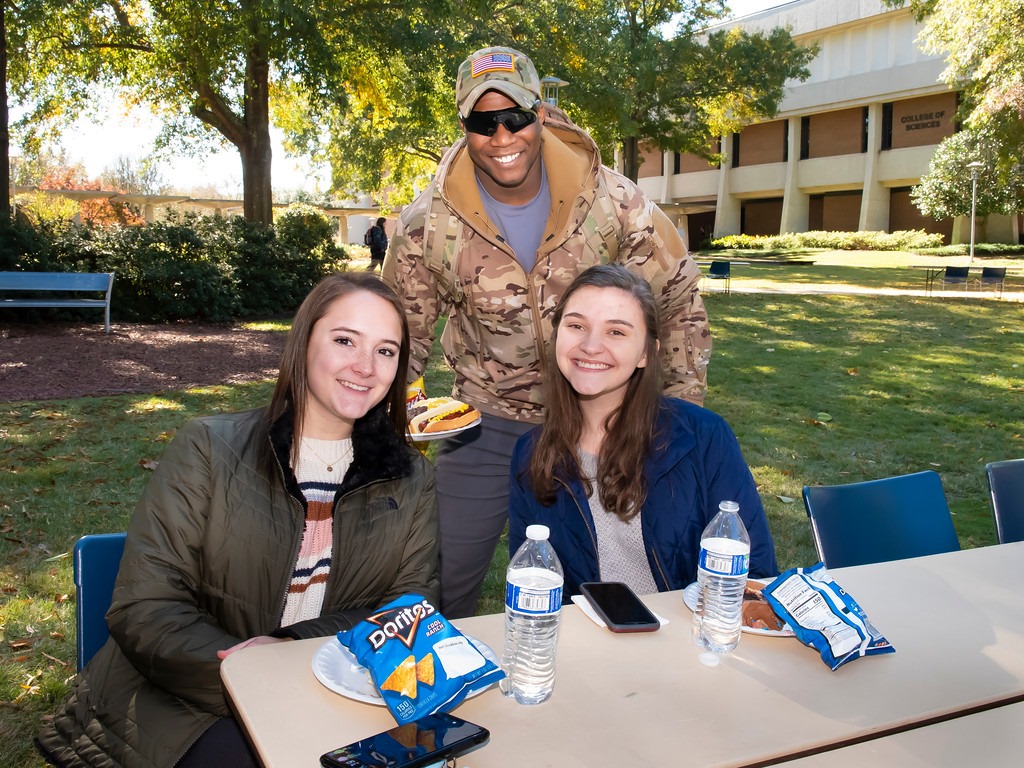a group of people sitting at a table posing for the camera