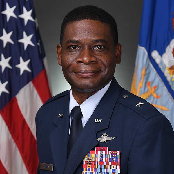 a man wearing a suit and tie smiling at the camera