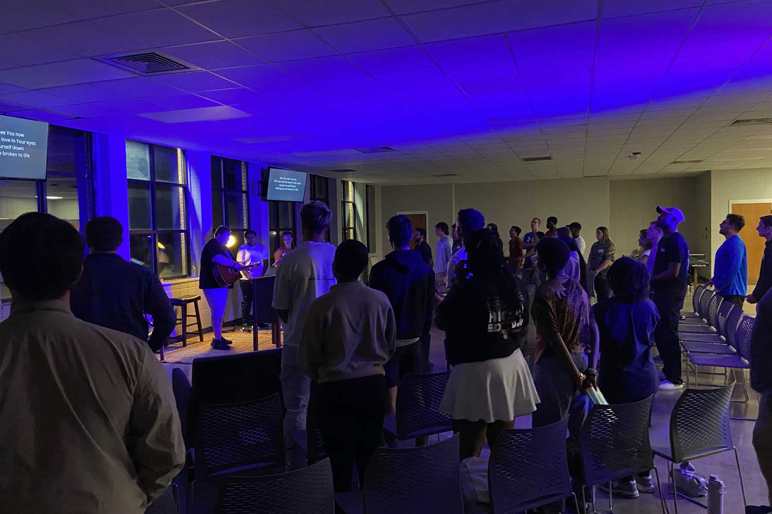 Students gather in a dimly lit auditorium at Auburn University at Montgomery for a presentation or event.