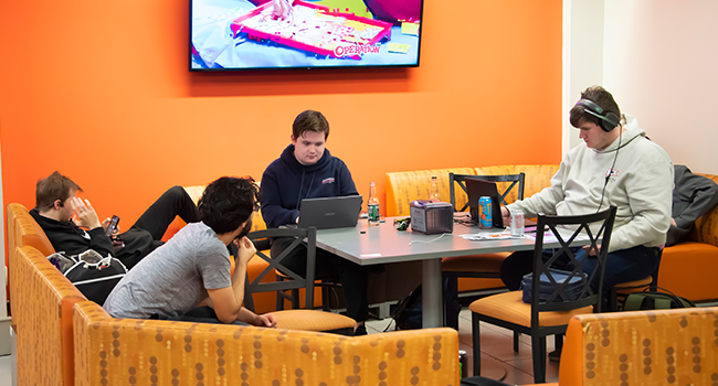 a group of people sitting at a table in front of a television