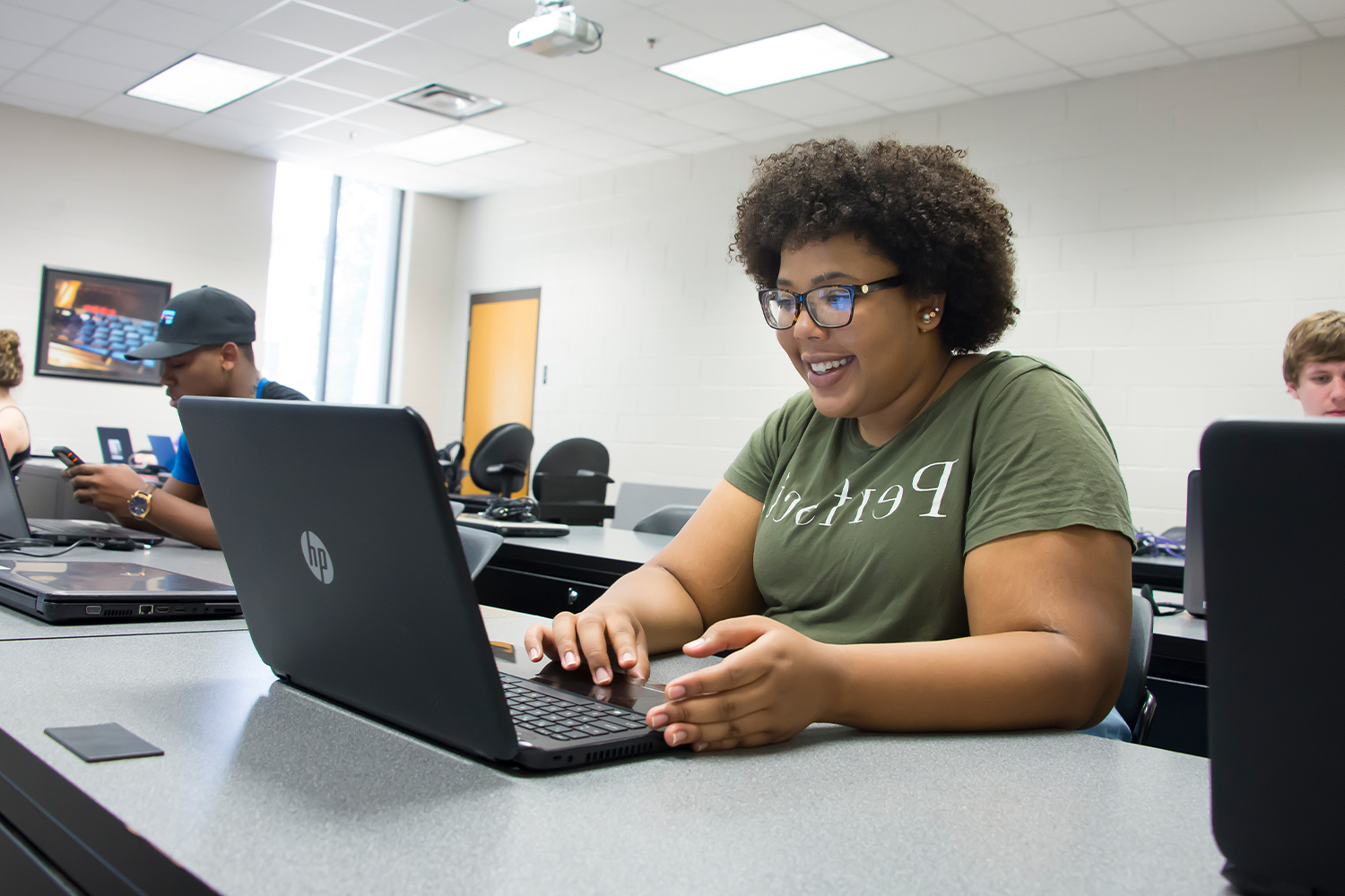 a person sitting at a table using a laptop computer