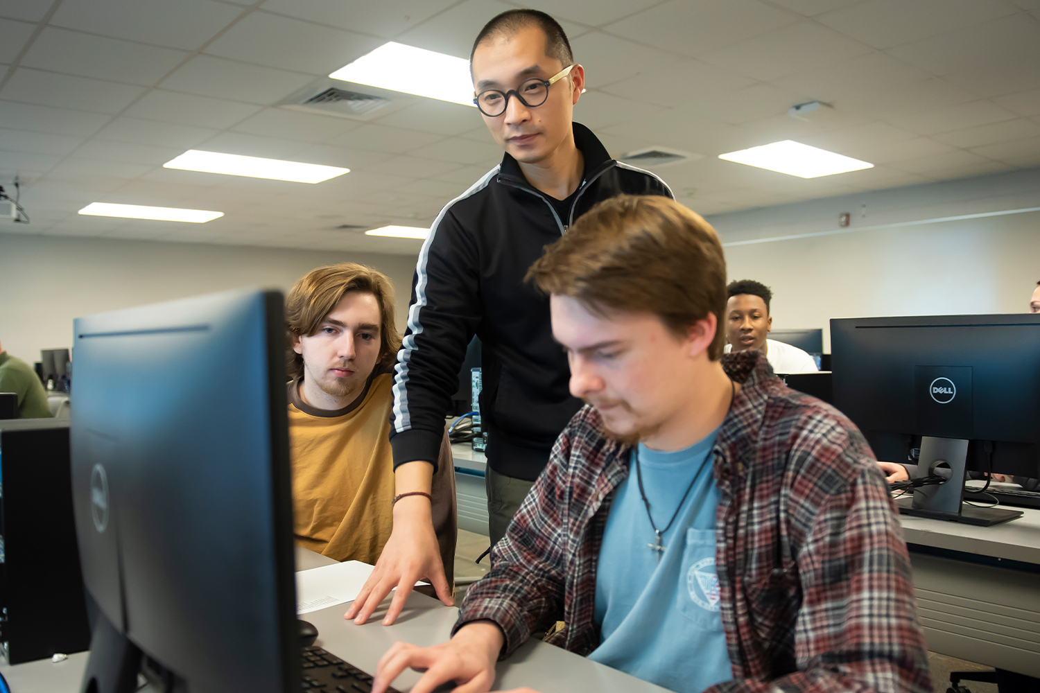 a man and a woman standing in front of a computer