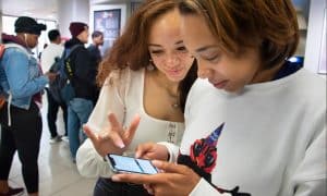 students reading the news on a mobile deivce