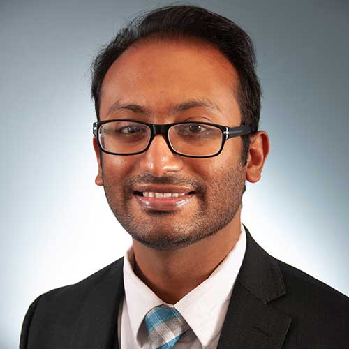 a man wearing glasses posing for the camera