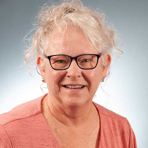 a person wearing glasses and smiling at the camera
