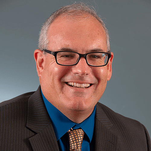 a man wearing glasses and a suit and tie