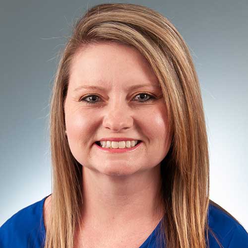 a woman wearing a blue shirt and smiling at the camera