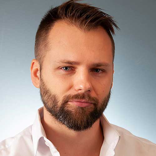 a man wearing a pink shirt is looking at the camera
