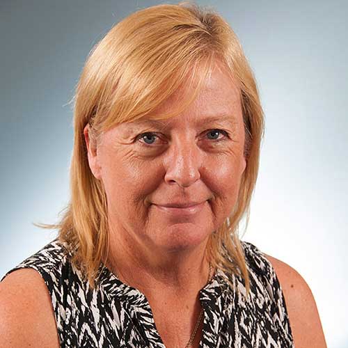 a woman wearing glasses and smiling at the camera