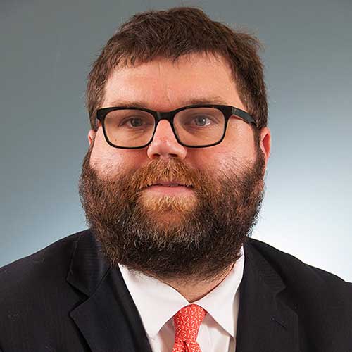 a man wearing glasses posing for the camera