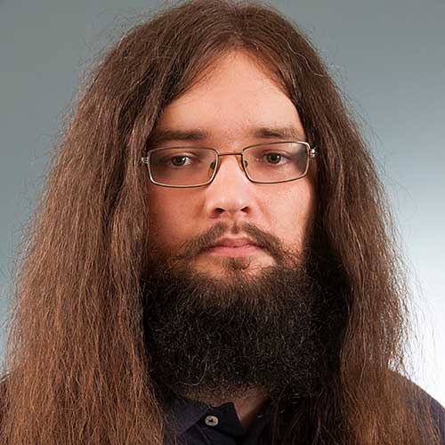 a close up of a man with long hair wearing glasses